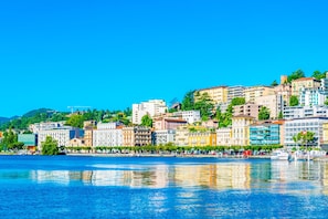 A waterfront cityscape with buildings along the river. - Icon H 506 Suite Business (Lugano)