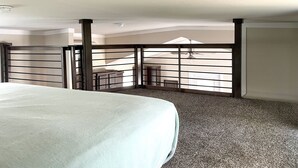 A hotel room with a bed, a balcony with a view, and a ceiling fan. - Cozy Tiny Home in the Hills (Fischer)