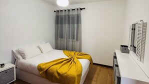 Une chambre à coucher moderne avec un lit, une table de chevet et un bureau.