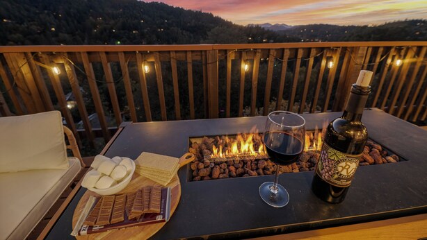 En balkon med bålsted, vin og snacks.