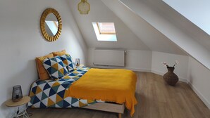 A bedroom with a bed, a mirror, a skylight, and a radiator. - Le Sunny - Spacious, renovated duplex apartment (Outreau)