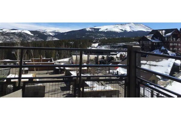 A view from a window overlooking a snowy landscape with mountains in the background.