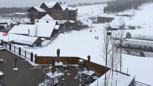 A snow-covered resort with chalet-style buildings, outdoor seating, and a ski slope in the background. - Breckenridge Grand Colorado; 3 BR; 2/14-2/18/21 (Breckenridge)
