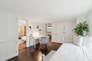 A bedroom with a bed, a desk, and a chair. There is a wardrobe and a plant. - Stunning Historic Maine Stone Castle (Bath)