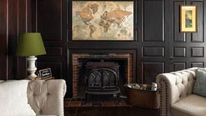A room with a fireplace, a world map on the wall, a lamp, and a sofa. - Stunning Historic Maine Stone Castle (Bath)
