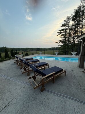 A poolside area with lounge chairs and a pool. - Stunning Historic Maine Stone Castle (Bath)