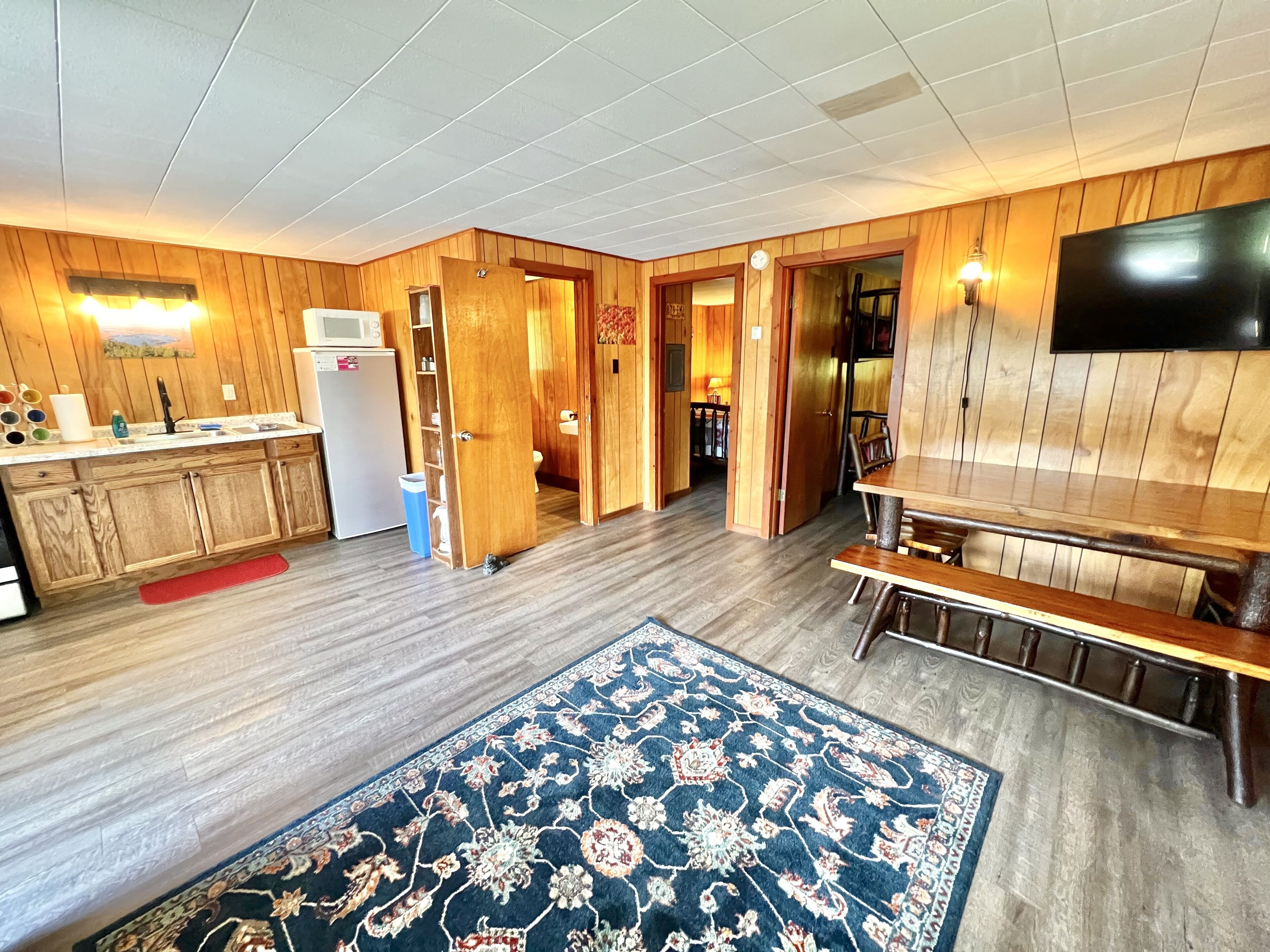 A spacious living area with a kitchen, a dining table, and a TV.