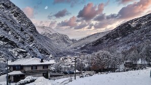 A snow-covered mountain village with traditional houses and a clear sky. - Mezzanine apartment in an alpine hamlet (Roure)