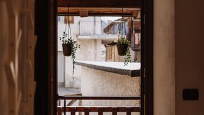 A wooden door frame with two hanging baskets of greenery. - Mezzanine apartment in an alpine hamlet (Roure)