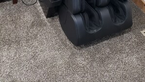 A black massage chair in a room with a wooden table and a carpeted floor. - Ohio Street Retreat-hot tub, pool, massage chair (Prairie du Chien)