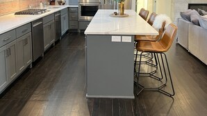 A modern kitchen with a central island, stainless steel appliances, and a bar area with stools. - Premier penthouse  w Private Rooftop near Memorial Stadium & Pinnacle Arena!   (Lincoln)