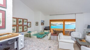 Ein kompakter Wohnbereich mit Essbereich, einer Küche mit Mikrowelle, einem Fernseher und Meerblick.