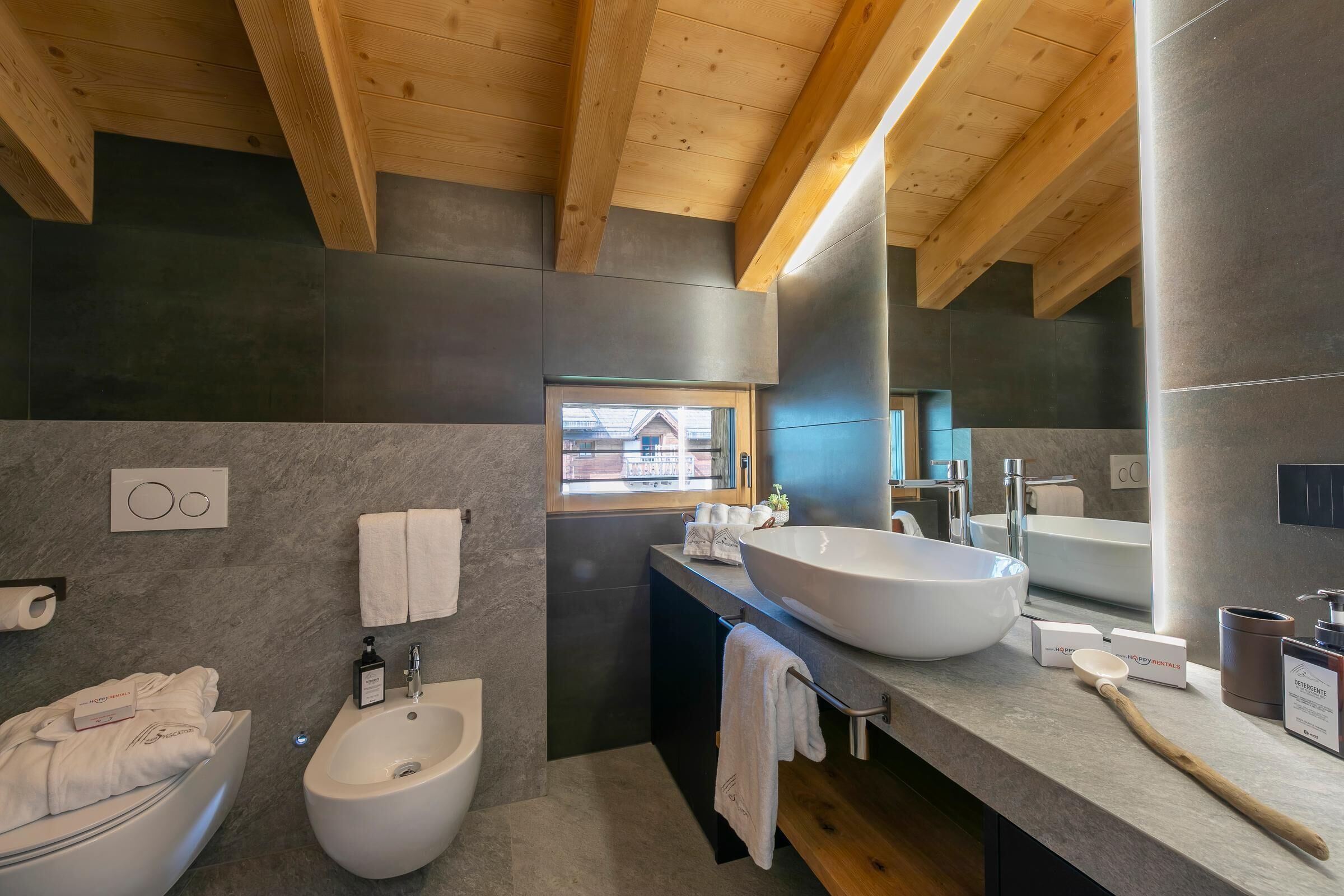 Un bagno moderno con bidet, lavandino capiente e specchio.