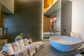 A modern bathroom with a large white sink, a towel rack, a small potted plant, and a wooden bench. - Lucia in Livigno With 2 Bedrooms and 2 Bathrooms (Livigno)