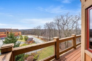 Une terrasse en bois offrant une vue sur un quartier résidentiel, avec des maisons et une route.