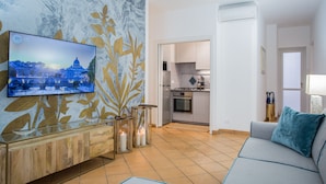 Una sala de estar moderna con un televisor de pantalla plana, un sofá y una decoración de pared.
