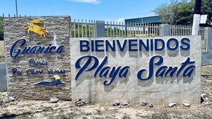A welcome sign for Playa Santa with a crab logo and a wave design.