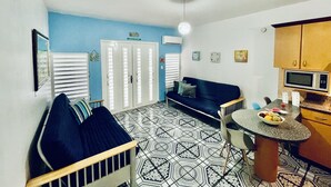 A compact living space with a kitchenette, a dining area, and a sofa.