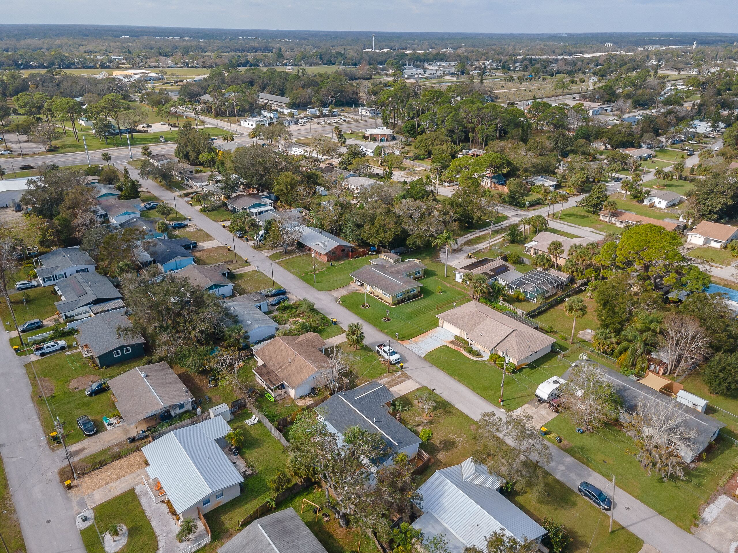 An aerial view of a residential area with houses, streets, and green spaces.