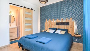 A bedroom with a bed, a wooden headboard, a nightstand, and a wall-mounted sign. - Amazing home in Angerville-l'Orcher with WiFi (Angerville-l'Orcher)