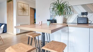 A modern kitchen with a wooden countertop, bar stools, a potted plant, and a kitchen island. - Amazing home in Angerville-l'Orcher with WiFi (Angerville-l'Orcher)