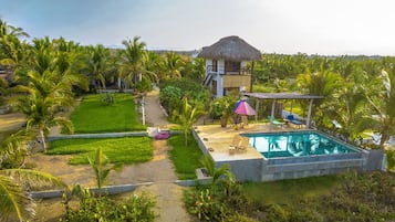 Alberca al aire libre, sombrillas en la alberca y camastros