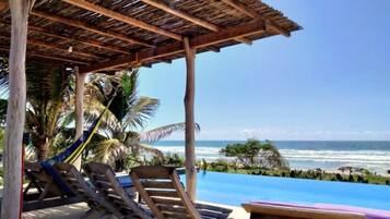 Alberca al aire libre, sombrillas en la alberca y camastros