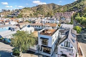 A residential area with a mix of modern and traditional architecture, including a house with a unique spiral design on the roof.
