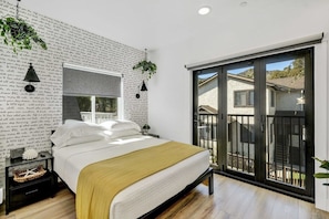 A bedroom with a bed, a window, a balcony, and a wall with text.
