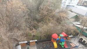 Une aire de jeux avec un toboggan, des balançoires et une structure d’escalade.