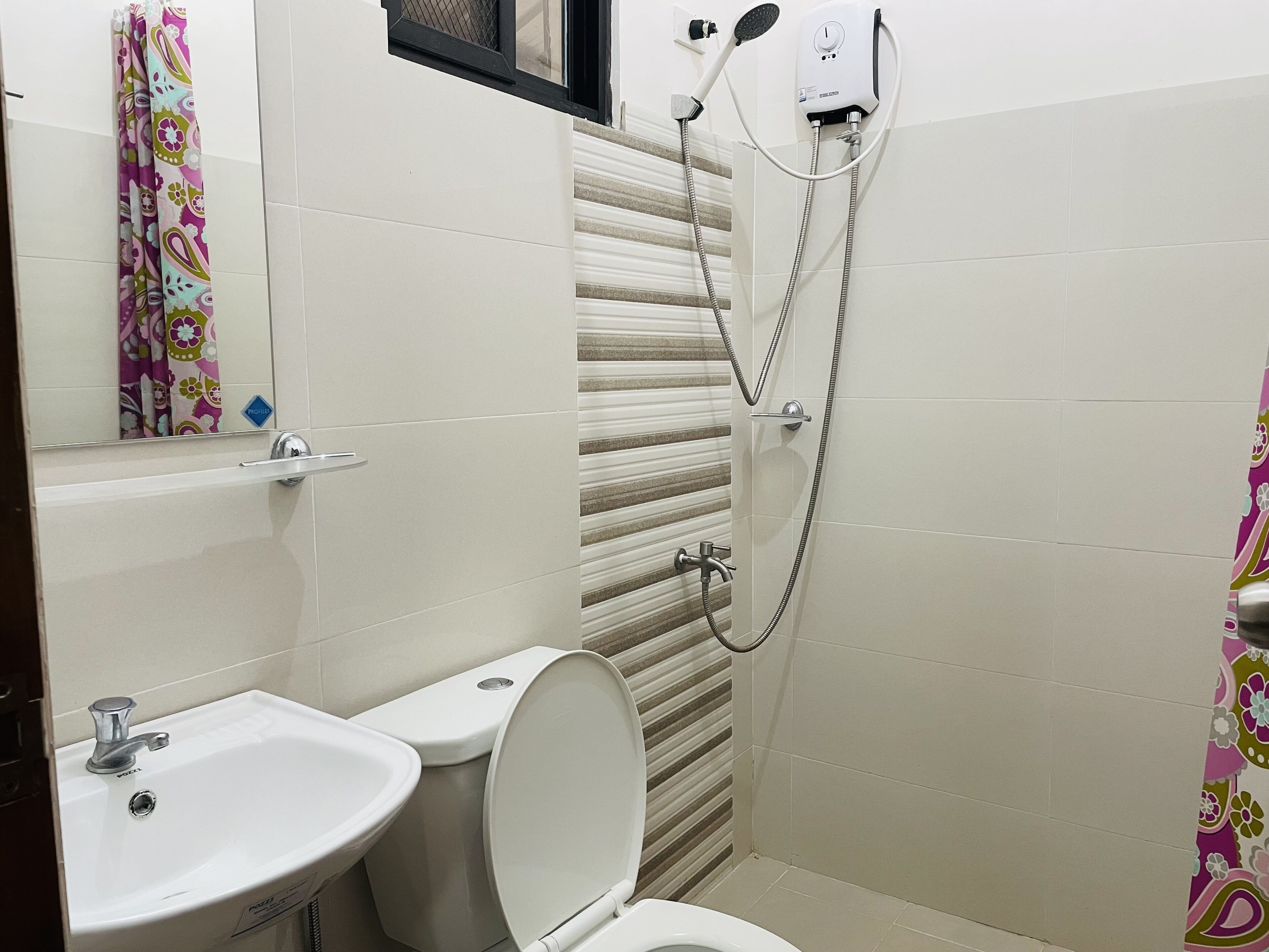 Un baño con inodoro, lavamanos y ducha.