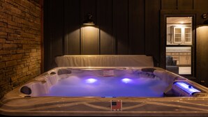 A hot tub with a label indicating it is made in the U.S.A., surrounded by wooden walls and a brick section.