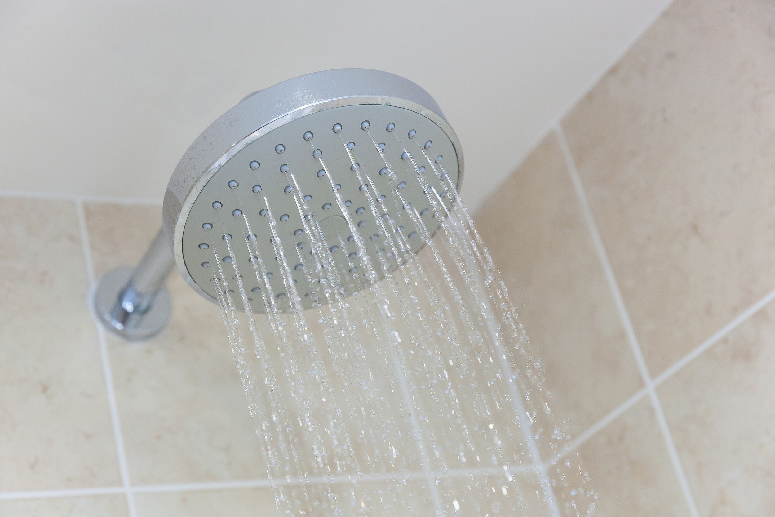 A showerhead with water flowing from it.