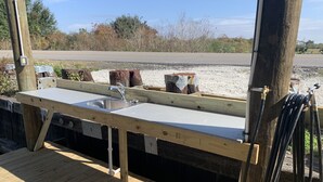 Una terraza de madera con un lavabo y grifo integrados.