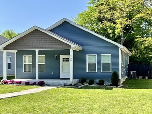 A two-story house with a front porch, a garage, and a well-maintained lawn.