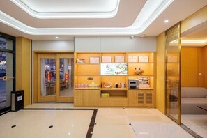 A hotel lobby with a reception desk, seating area, and a wall with framed certificates. - Super 8 Hotel (Quanzhou Nan'an Hongse Laifulong Shopping Plaza) (Nan'an)