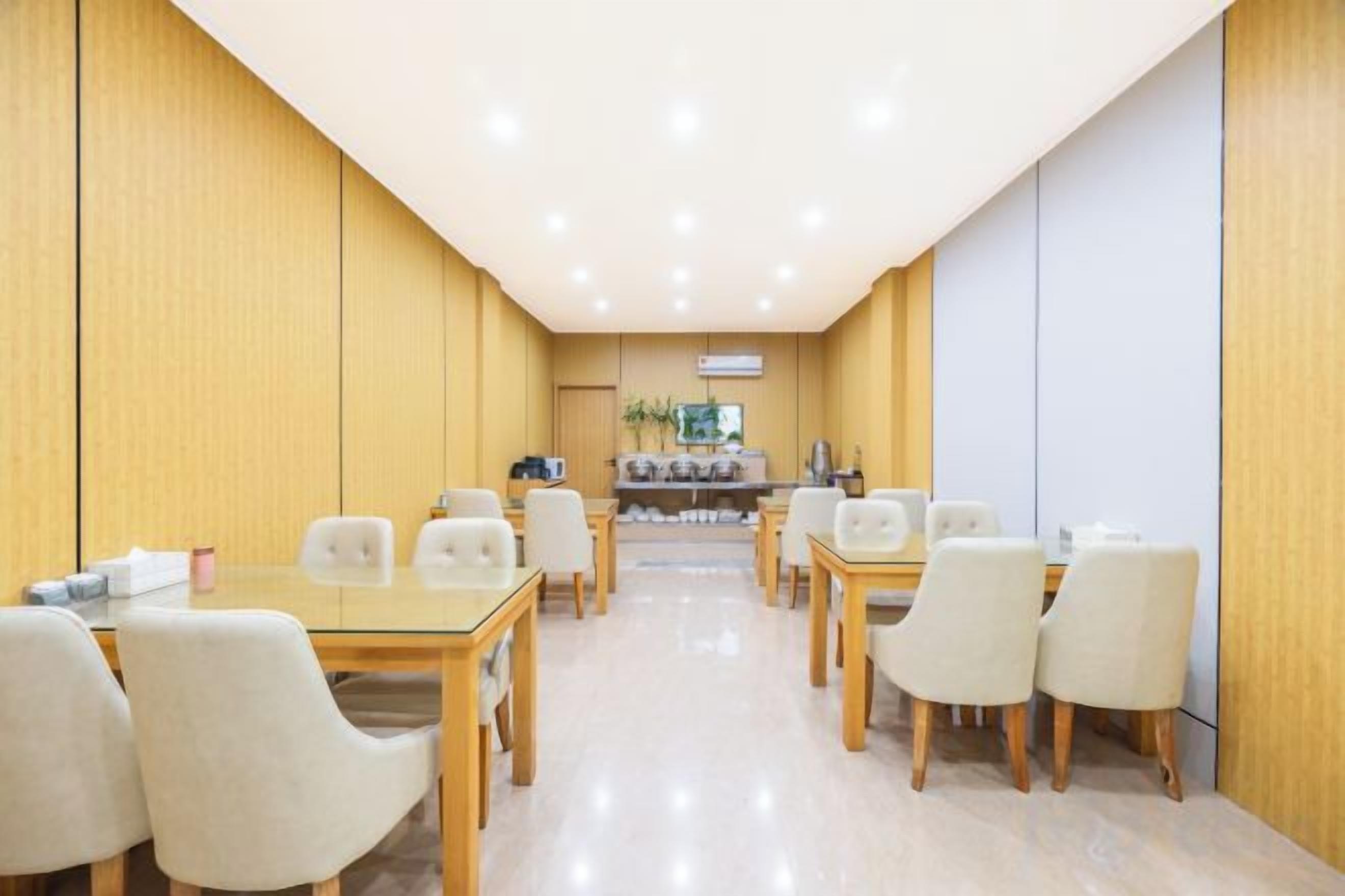 A conference room with a long table and chairs, a reception desk, and a wall-mounted television.