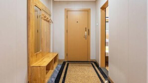 A hallway with a wooden bench, a door, and a patterned rug. - Super 8 Hotel (Quanzhou Nan'an Hongse Laifulong Shopping Plaza) (Nan'an)