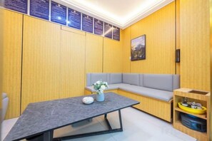 A modern room with a grey sofa, a small table with a vase, and a wooden cabinet. - Super 8 Hotel (Quanzhou Nan'an Hongse Laifulong Shopping Plaza) (Nan'an)