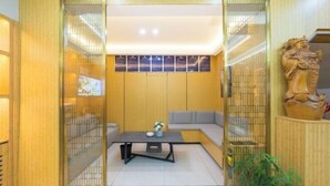 A modern interior with a sofa, a coffee table, and a decorative statue. - Super 8 Hotel (Quanzhou Nan'an Hongse Laifulong Shopping Plaza) (Nan'an)