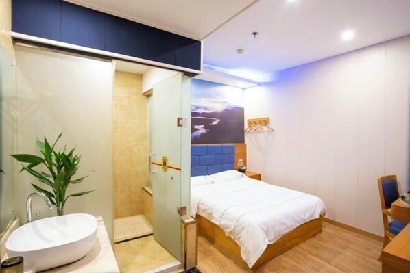 A modern hotel room with a large bed, a bathroom with a sink and shower, and a view of the cityscape. - Super 8 Hotel (Quanzhou Nan'an Hongse Laifulong Shopping Plaza) (Nan'an)