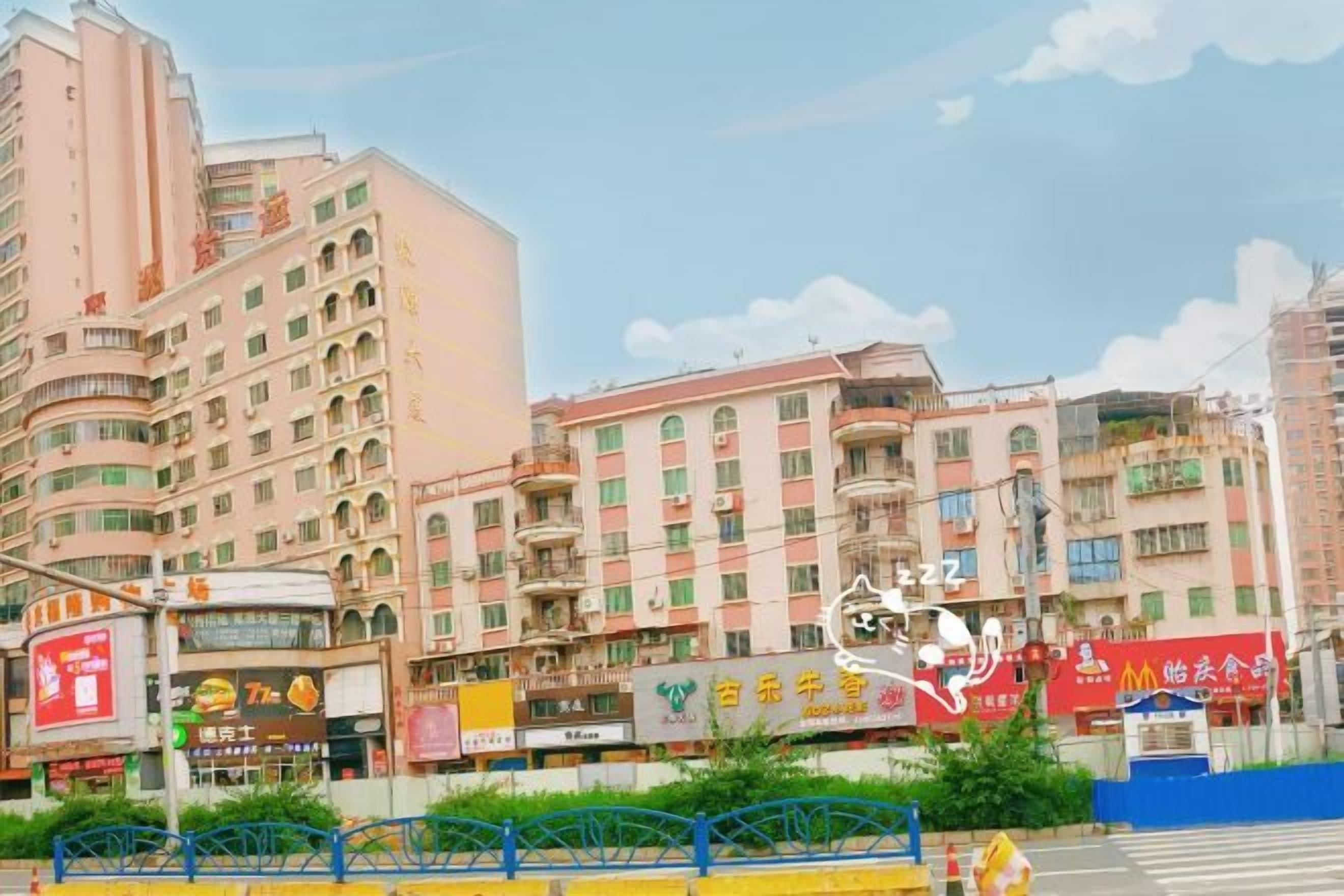 Um edifício de vários andares com letreiros comerciais, varandas e uma faixa de pedestres.