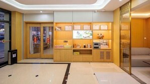 A modern hotel lobby with a reception desk, seating area, and a wall displaying certificates. - Super 8 Hotel (Quanzhou Nan'an Hongse Laifulong Shopping Plaza) (Nan'an)
