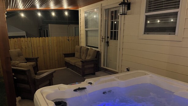 Ein Whirlpool mit blauem Licht, eine Holzterrasse und Sitzgelegenheiten im Freien.