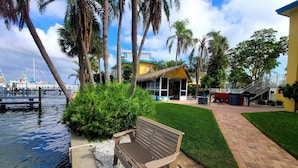 A waterfront property with a bench, a thatched-roof structure, and a paved walkway. - Waterside studio in the heart of Treasure Island, walk to beach (Treasure Island)