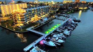 A marina with boats docked, a waterfront hotel with multiple balconies, and a bridge connecting to the dock. - Waterside studio in the heart of Treasure Island, walk to beach (Treasure Island)