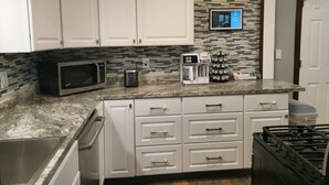 A kitchen with white cabinets, a microwave, toaster, coffee maker, and a gas stove. - The Railroad Ranch - Station Five (Youngstown)