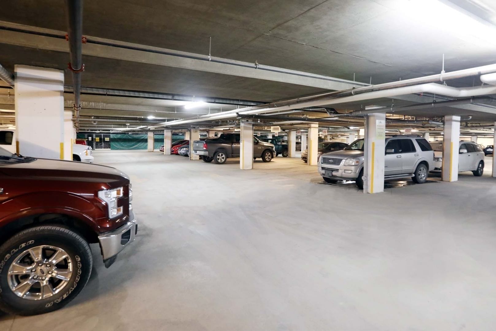 Eine mehrgeschossige Tiefgarage mit Betonpfeilern und Deckenbeleuchtung.