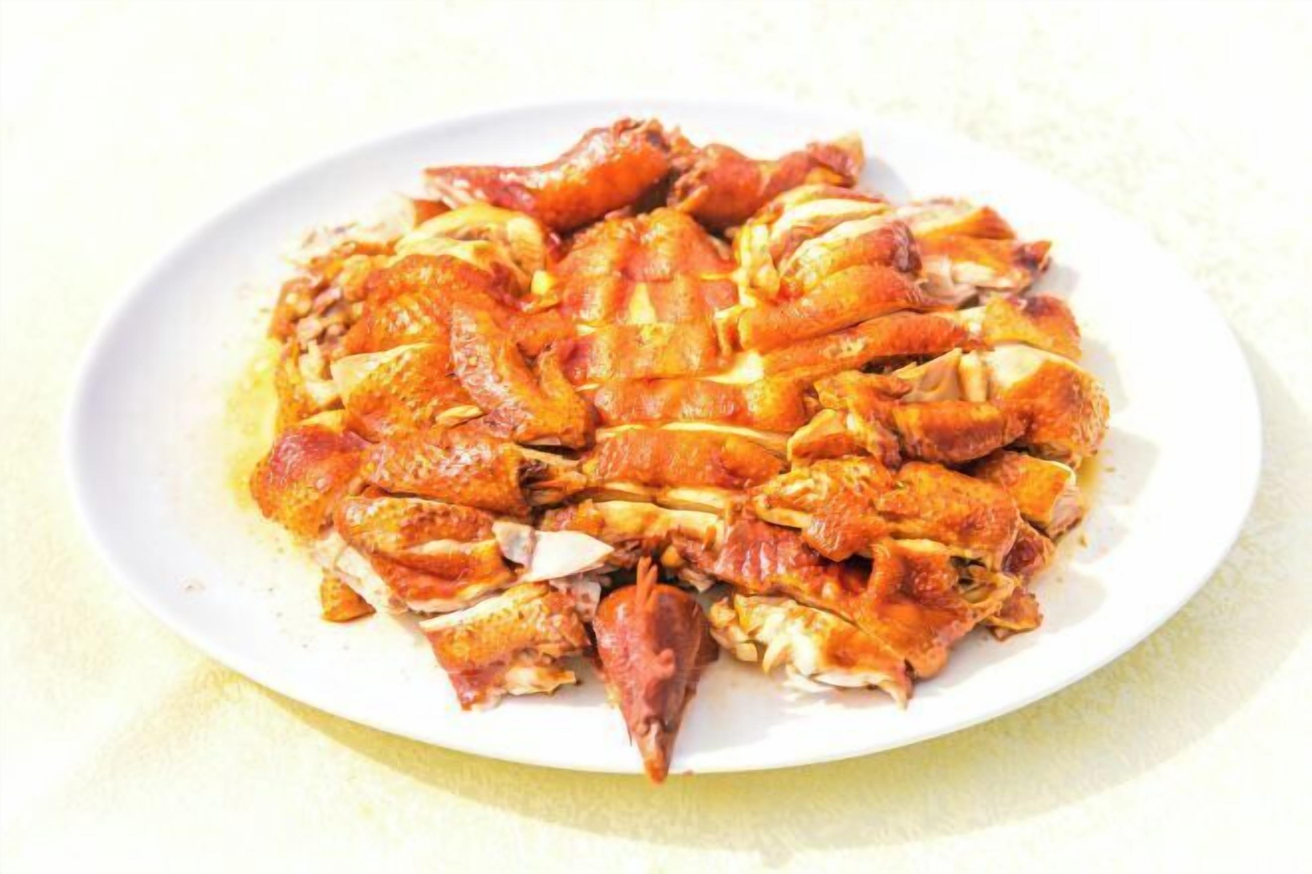 A white plate with cooked crab pieces.