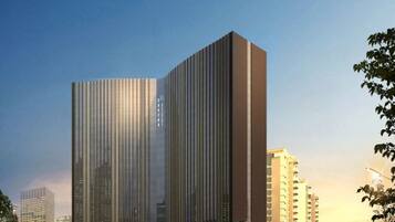 A modern high-rise building with a unique vertical design, surrounded by other high-rise buildings.